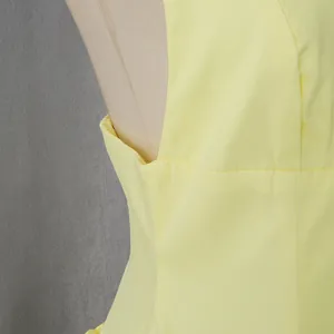 Close-up of the underarm seam and fabric texture on a light yellow French retro style dress