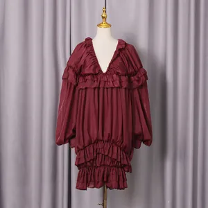 Dettaglio di un abito bordeaux a balze con elegante scollo a V e maniche a palloncino