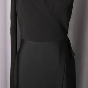 Nahaufnahme eines schwarzen One-Shoulder-Abendkleids mit feiner Stoffstruktur und Taillen-Detail