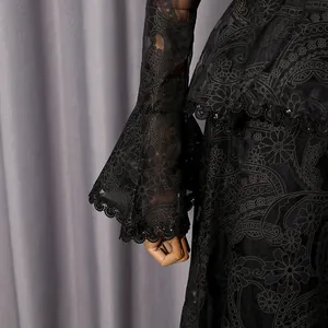 Close-up of elegant black lace bell sleeves and intricate floral embroidery details