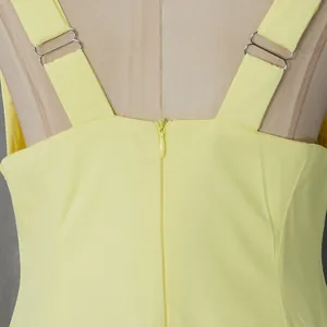 Close-up of the back zipper and adjustable wide straps on a light yellow French dress.