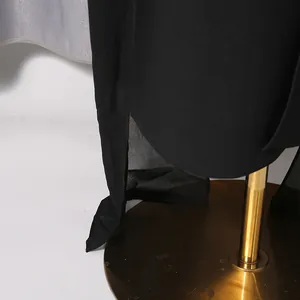 Detailansicht eines eleganten schwarzen Abendkleids mit Schlitz und fließendem Saum