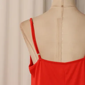 Détail de la fine bretelle réglable sur une robe rouge vif de style rétro français