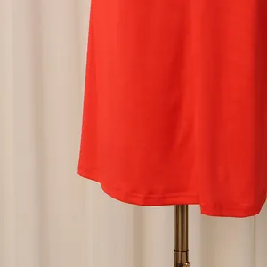 Vue détaillée de l'ourlet d'une robe rouge montrant les coutures et la texture du tissu