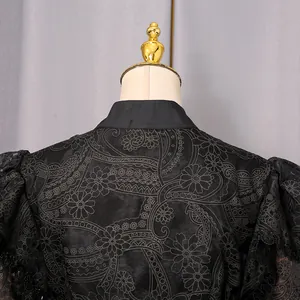 Close-up detail of a vintage black dress featuring intricate floral embroidery and lace
