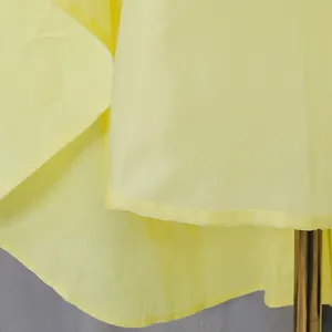 Detailed view of the yellow fabric and hem stitching on an elegant French vintage dress