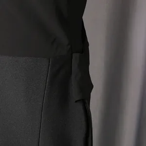 Detailaufnahme eines eleganten schwarzen Abendkleids mit Stofftexturen und Bandverzierung