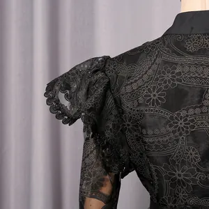 Close-up of intricate floral embroidery and lace on black vintage style puff sleeve dress