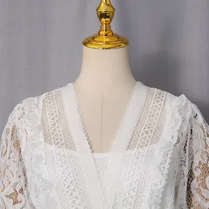 Close-up of white hollow lace embroidery on a vintage V-neck court style dress