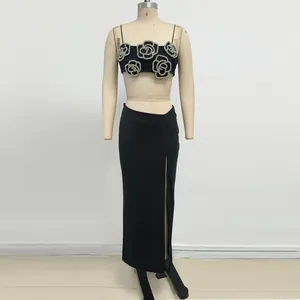 Elegante completo nero due pezzi con crop top a camelia e gonna lunga con spacco alto