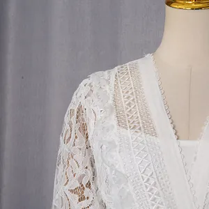 Detailed macro view of vintage white hollow-out lace dress with ruffle trim neckline