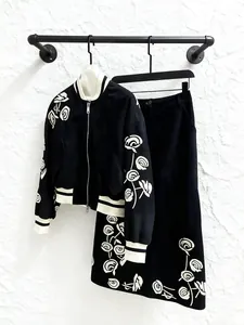 Elegantes Retro-Set mit bestickter Baseballjacke und schwarzem Midirock für Damen.