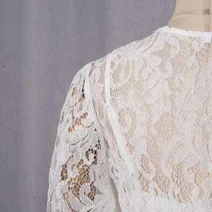 Detailed macro shot of intricate white floral lace on a retro long-sleeve dress