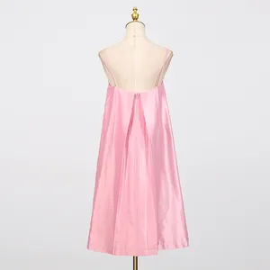 Gedetailleerd achteraanzicht van roze satijnen slipdress met plooien en losse pasvorm