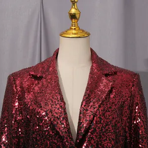 Detalle de un blazer de lentejuelas rojas y negras que muestra la textura brillante y solapa.