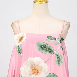 Detailopname van het prachtige bloemenborduurwerk op een roze vintage Chinese jurk