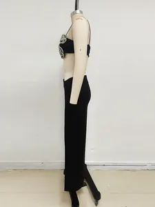 Elegante set abito da sera nero due pezzi con crop top di strass e gonna lunga aderente.