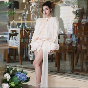 Elegantes cremefarbenes Langarm-Minikleid mit Taillenbindung und langem fließendem Band