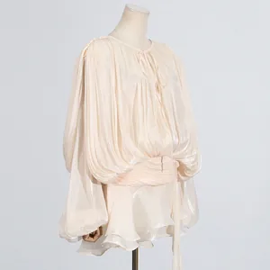 Side view detail of champagne pleated mini dress with lantern sleeves and tie-neck