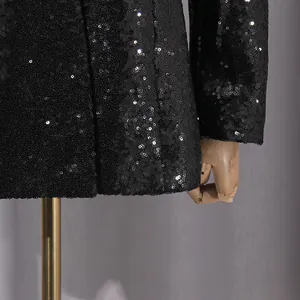 Primer plano del tejido de lentejuelas negras brillantes en una chaqueta blazer mujer