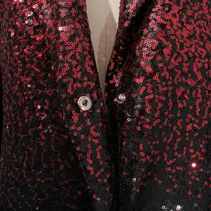 Detalle de cerca de un blazer de lentejuelas rojas y negras con cierre de botón de presión metálico