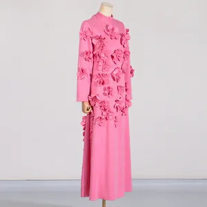 Detail view of a pink long sleeve dress with 3D floral appliqués displayed on a mannequin stand