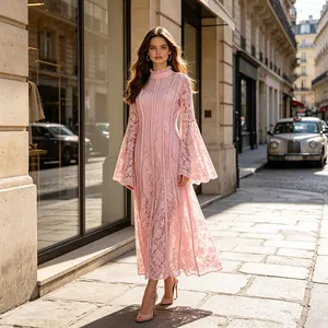 Detailed view of elegant pink lace dress with bell sleeves on a Parisian street.