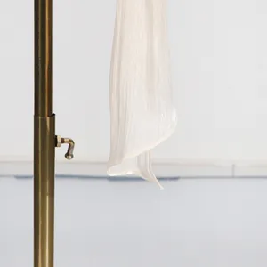 Close-up detail showing the white pleated fabric and texture of an elegant summer dress