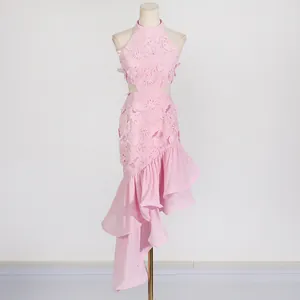Detail of pink resort dress featuring floral lace cutout waist and irregular ruffle hem