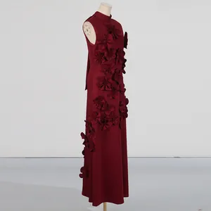 Detailed side view of elegant burgundy maxi dress with 3D floral appliqué on a mannequin.
