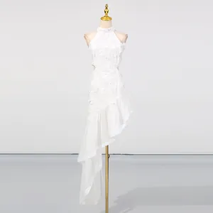 Full view of white resort style dress with asymmetrical ruffled hem and waist cut-outs