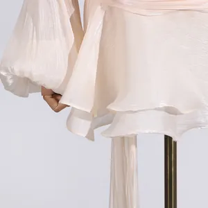 Close-up of shimmering pleated fabric and layered ruffles on a sweet style mini dress