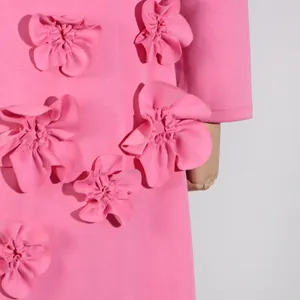 Close-up detail of 3D fabric flower appliqués on a bright pink long sleeve dress