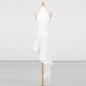 Rear view of white sleeveless resort dress featuring waist cut-outs and asymmetrical hem