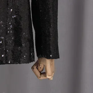 Detalle de cerca de las lentejuelas negras brillantes en la manga de un blazer de mujer