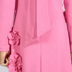 Close-up detail of pink long sleeve dress featuring exquisite 3D flower embellishments