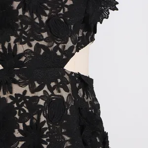 Close-up of black floral lace dress with hollowed out waist detail and embroidery