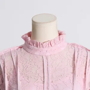 Close-up detail of high ruffled neck on a pink French elegant lace dress