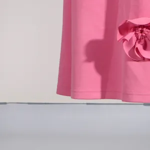 Detail shot of a pink A-line dress featuring a delicate and elegant 3D fabric flower