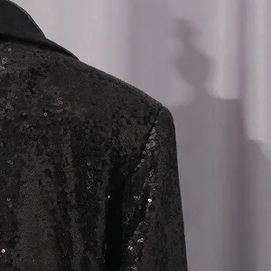Primer plano detallado de lentejuelas negras brillantes en un blazer de mujer.