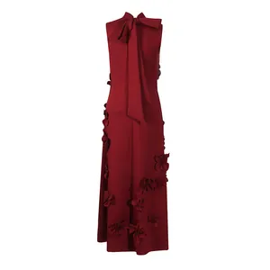 Detail of elegant burgundy sleeveless maxi dress with 3D floral appliqués and back bow.