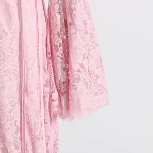 Close-up detail of delicate pink floral lace embroidery on a French style maxi dress