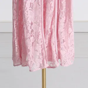 Close-up detail shot of delicate floral lace embroidery on elegant pink maxi dress hem