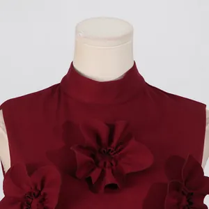 Detailed close-up of 3D fabric flower accents on a burgundy sleeveless stand collar dress