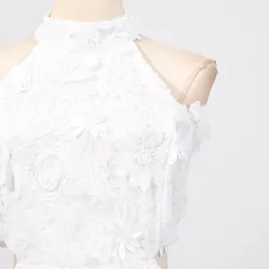 Close-up detail of exquisite white floral lace embroidery on a high-neck halter dress
