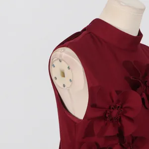 Close-up detail of French style burgundy sleeveless dress featuring 3D floral appliques