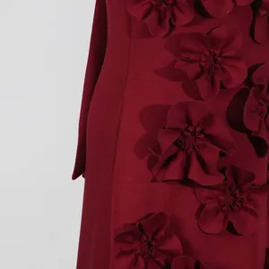 Macro view of 3D fabric flower appliqués on a burgundy French style sleeveless dress