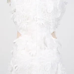 Detail view of intricate white 3D floral lace embroidery and side cut-outs on dress