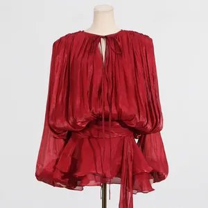 Close-up of red pleated mini dress with ruffles and tie-neck detail on a mannequin