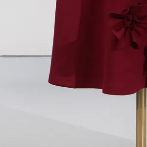 Detail shot of the wine red dress hemline and elegant 3D floral patchwork decoration